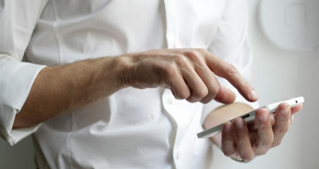 Iemand die een app op zijn gsm bedient